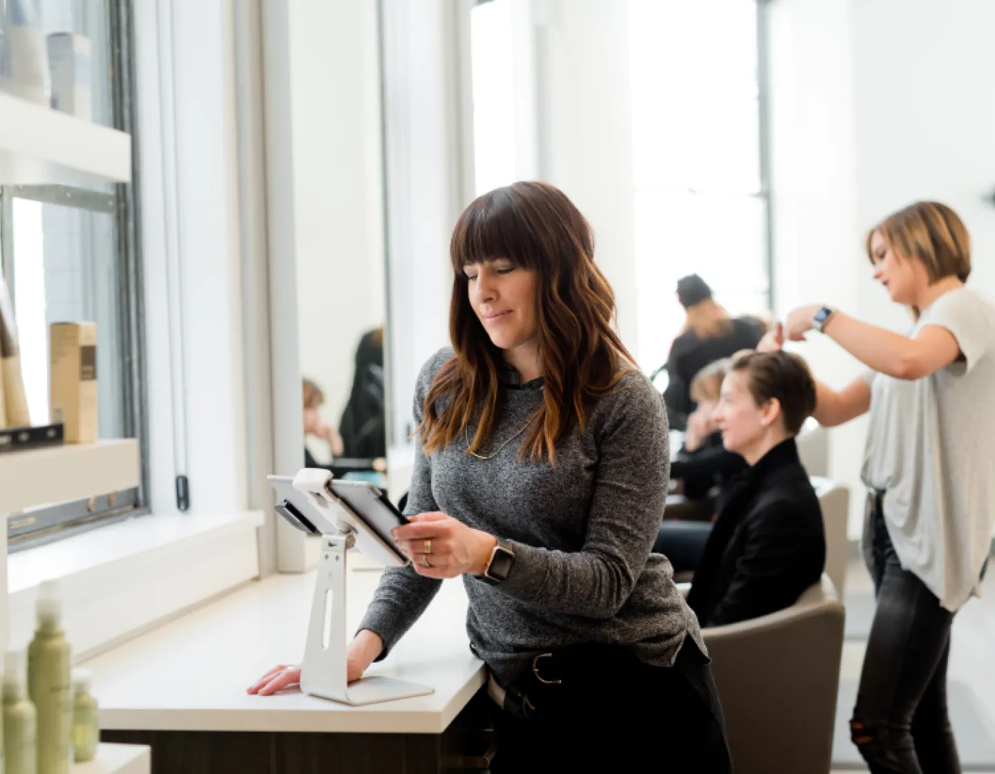 hairdresser in salon with tablet